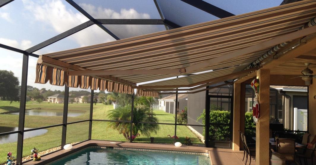 Motorized outdoor awning creating instant shade for relaxing, dining, and entertaining in this backyard space.