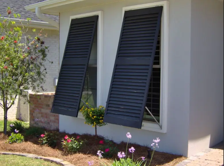 Stylish Bahama shutters installed on a home’s exterior, providing shade, storm protection, and a tropical aesthetic.