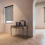 Contemporary double roller shades installed on a window, offering adjustable light control and privacy with alternating sheer and opaque fabric panels.