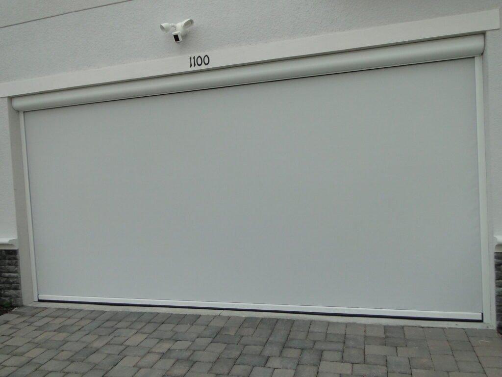 Retractable garage door screen extended, providing ventilation and protection from insects, creating a comfortable, open-air garage space