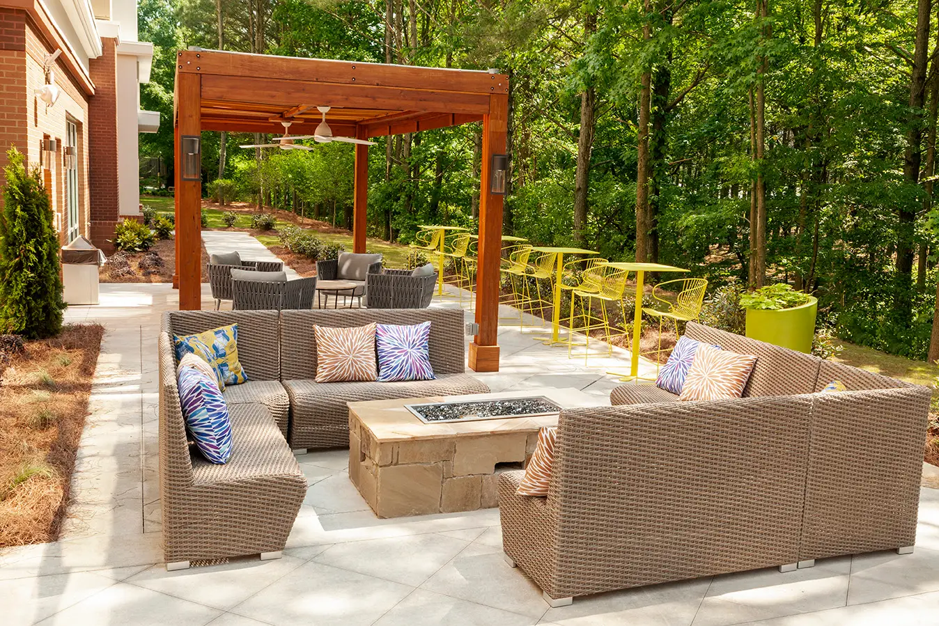 Outdoor lounge area featuring custom-designed furniture including modular seating, accent tables, and planters arranged on a stone patio.