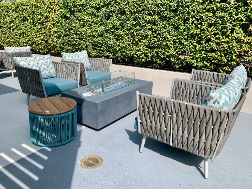 Upscale outdoor lounge area featuring custom seating and a modern fire feature, designed for comfort and ambiance.