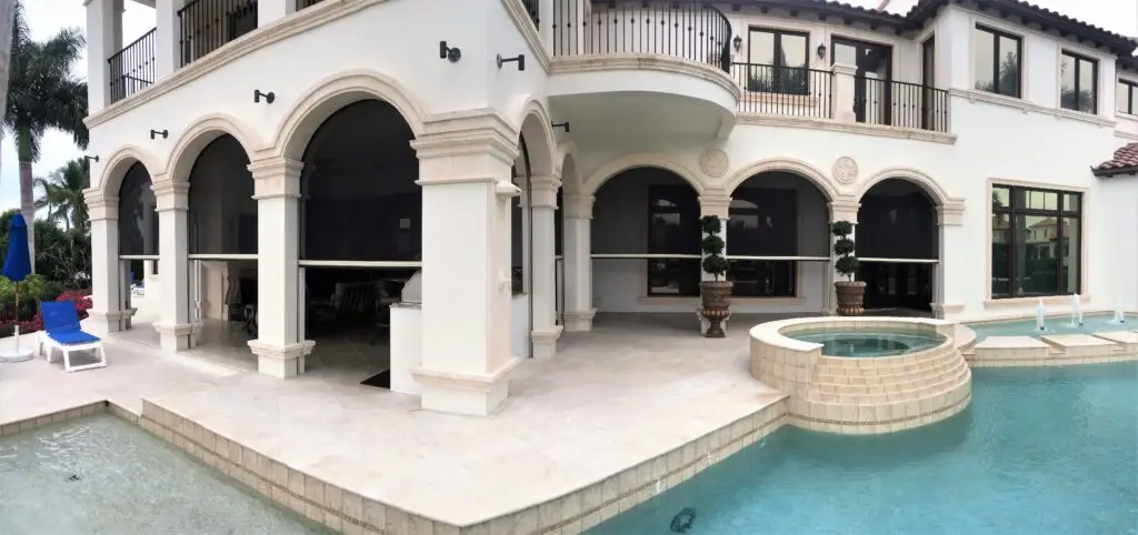 Motorized MagnaTrack solar shade screen installed on a lanai, providing sleek sun protection and enhanced outdoor comfort.