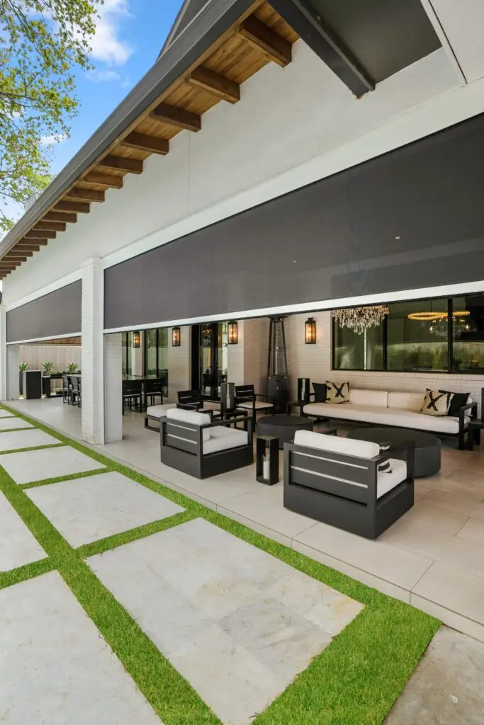 Progressive MagnaTrack motorized screens on a patio creating a shaded outdoor lounge with scenic views.
