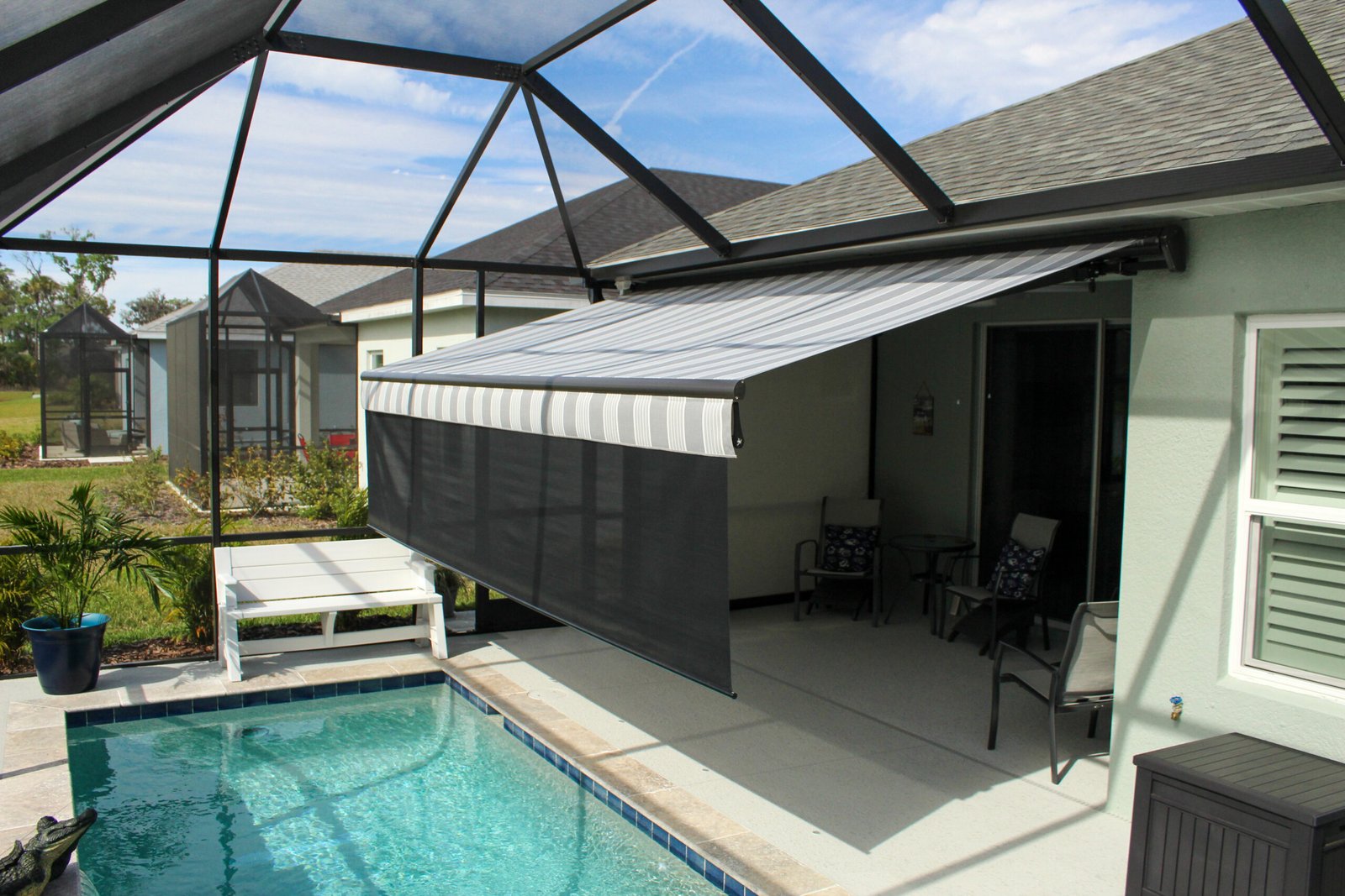 Motorized awning with a drop shade in pool area