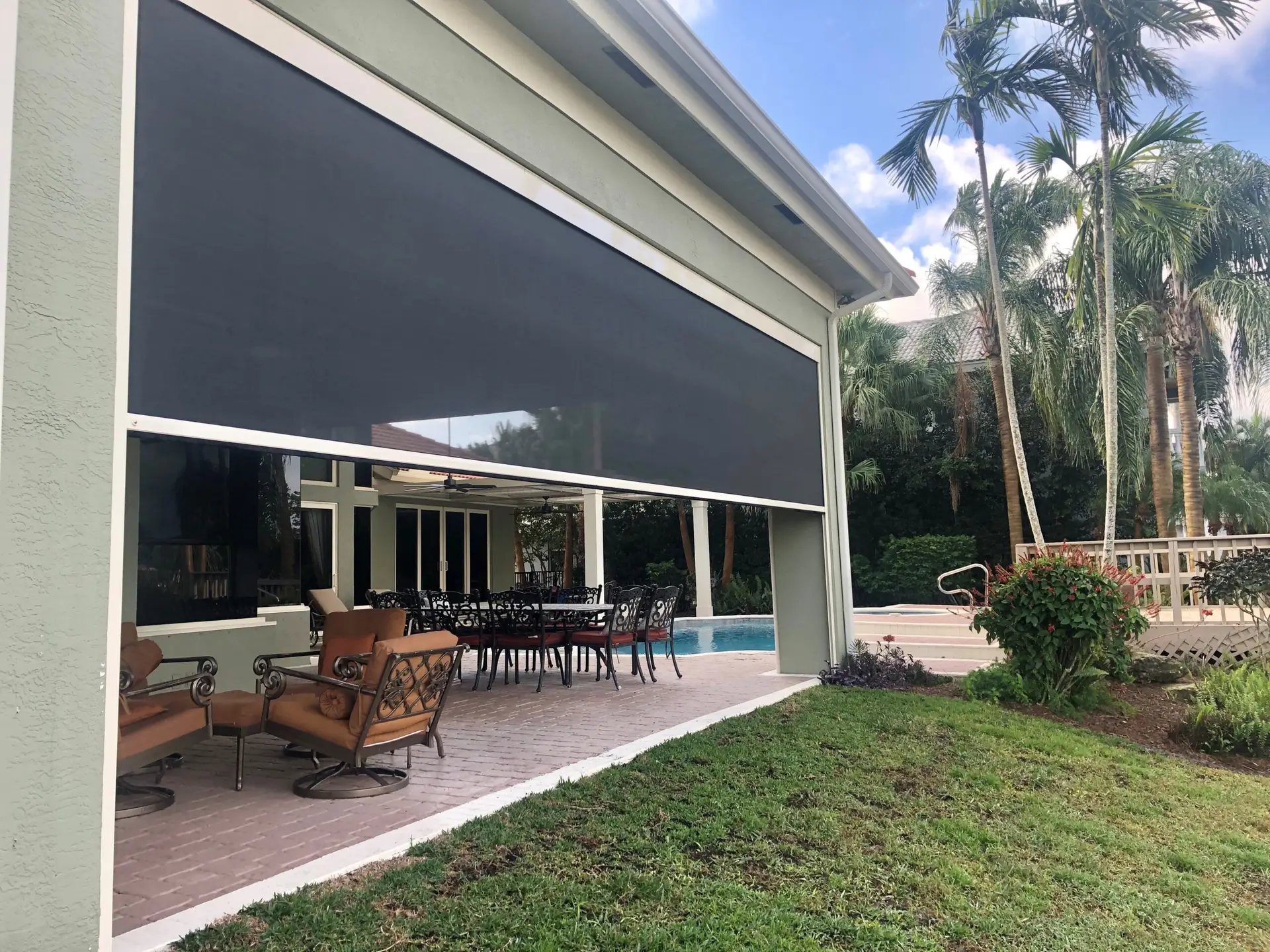 Custom motorized patio screens help create a cooler, more usable lanai with push-button convenience.